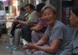elderly Chinese women talking on a curb