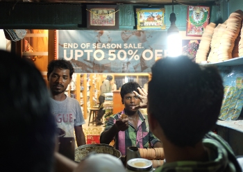 Men haggling in food stall in Kolkata, India